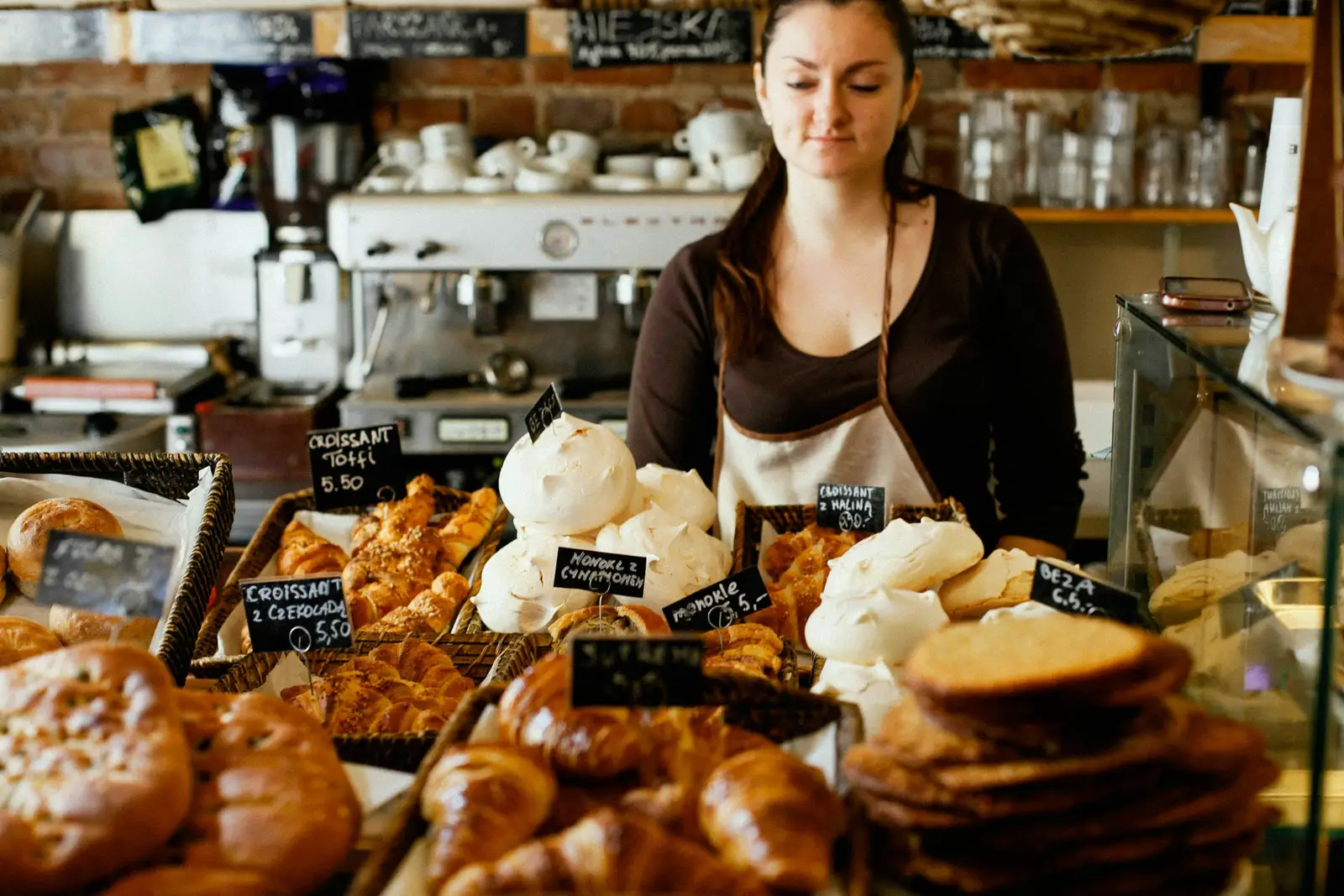 A baker at the counter surrounded by fresh loaves