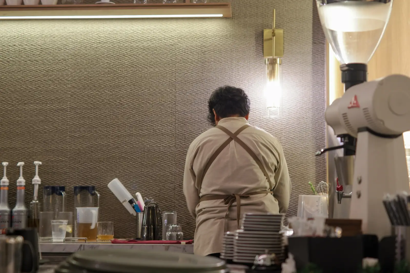 A barista preparing drinks behind a café counter